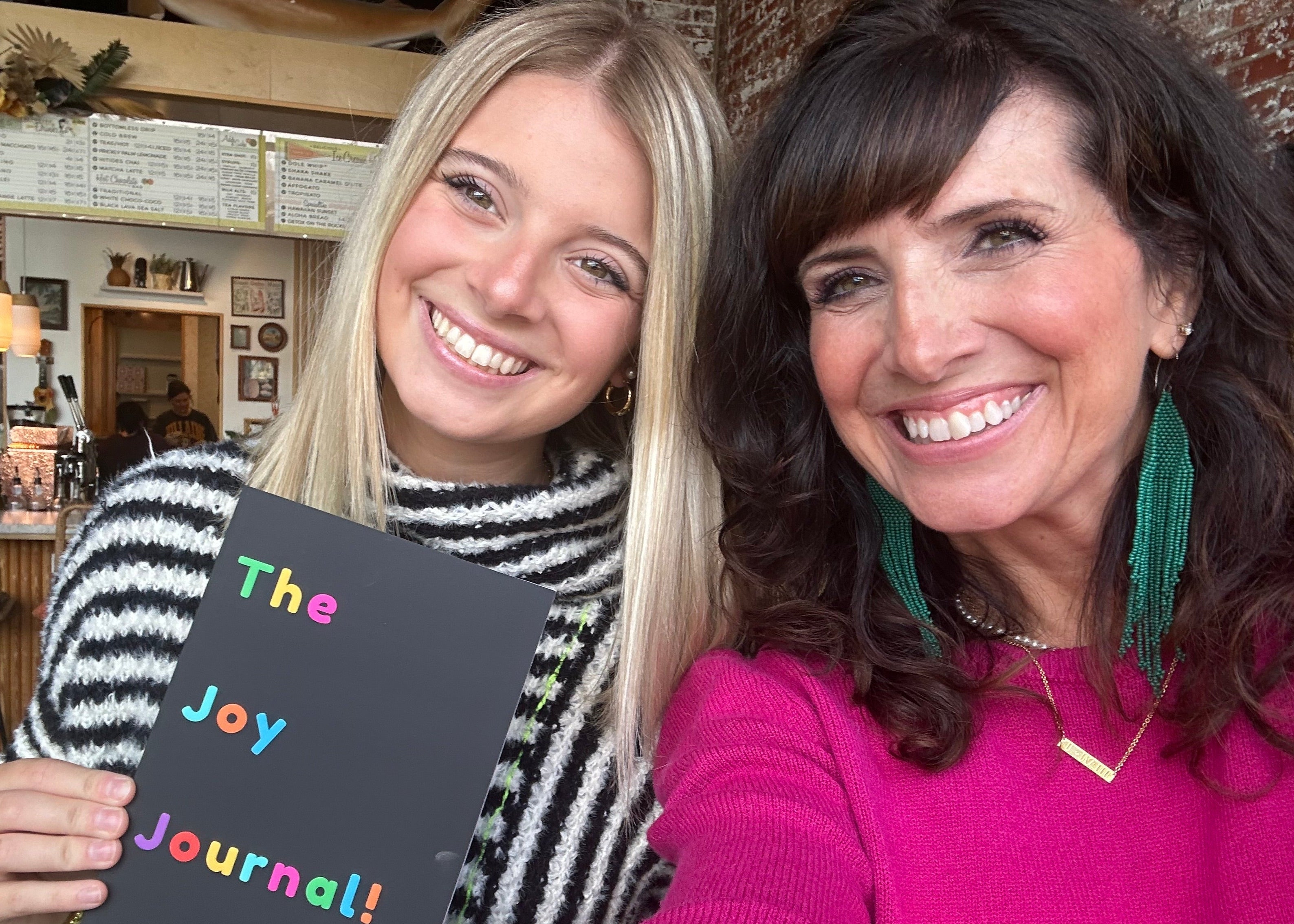 Two women holding a Joy Journal 